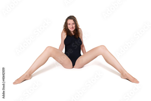 Smiling woman wearing a black swimsuit in front of white studio background