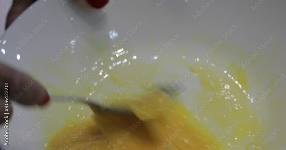 Woman beating egg yolks in a bowl with the form closeup. Woman beating egg yolks in a bowl with the form closeup.