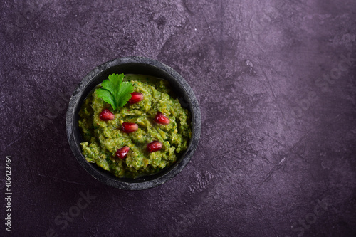 Green pkhali with pomegranate seeds on a dark stone table. photo