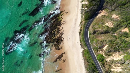 Rising drone shot of Shelly Beach and the Wellington Rocks with coastal highway and ocean waves at Nambucca Heads New South Wales Australia photo