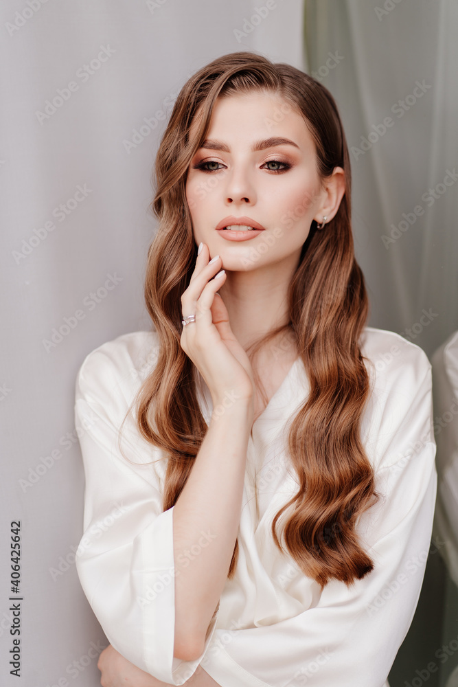 beautiful woman in white robe at the window.morning of bride before wedding beautiful woman in white robe at the window.morning of bride before wedding