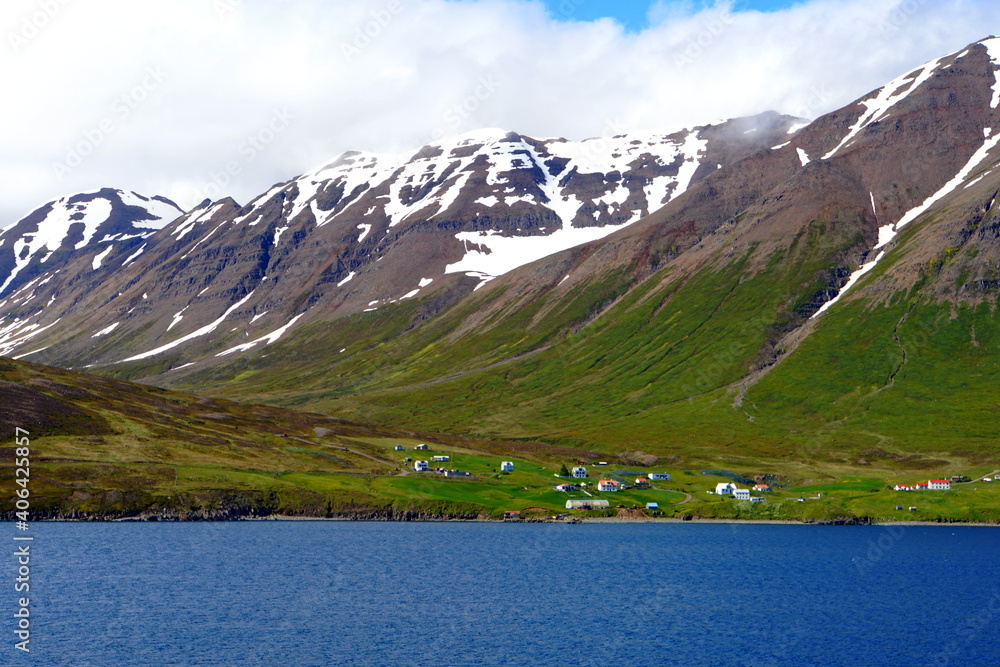 The spectacular view of the partially covered snowy mountain along the fjord near Olafsfjordur, Iceland The spectacular view of the partially covered snowy mountain along the fjord near Olafsfjordur, Iceland