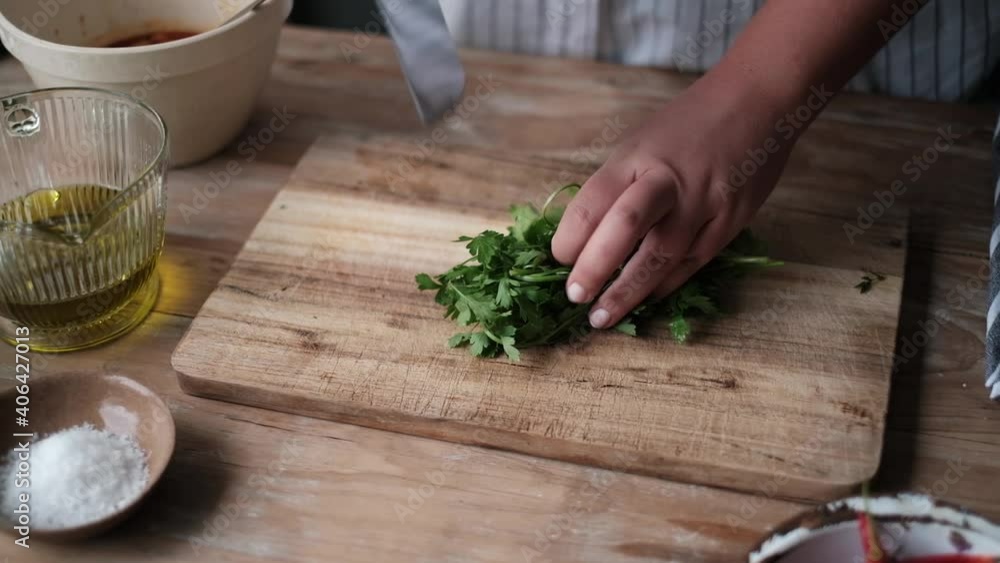 Chef cutting parsley on a wooden block. Chef cutting parsley on a wooden block.