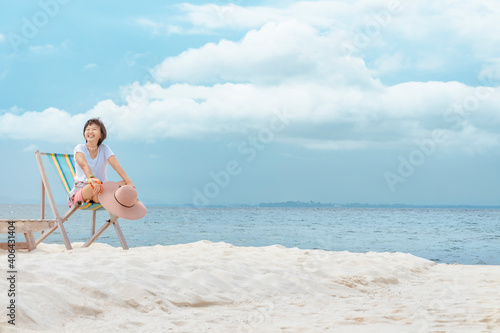 Asian woman Sit on a beach chair,Refreshment and enjoyment with nature concept.