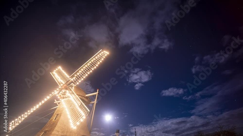 Windmill Illuminated In Lights Under A full moon Evening In Ameland, Netherlands - Low-Angle night Shot photo