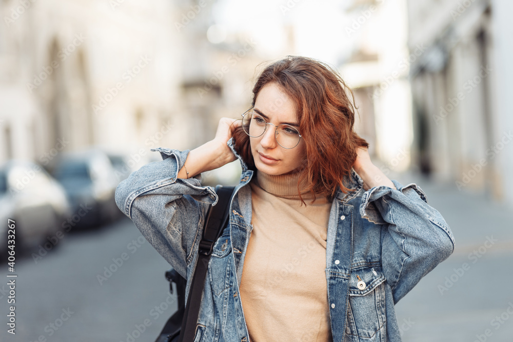 Fototapeta premium Stylish attractive woman in denim jacket on urban street