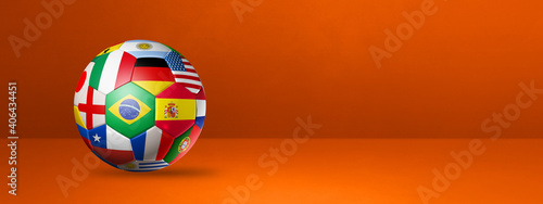 Football soccer ball with national flags on a orange studio banner