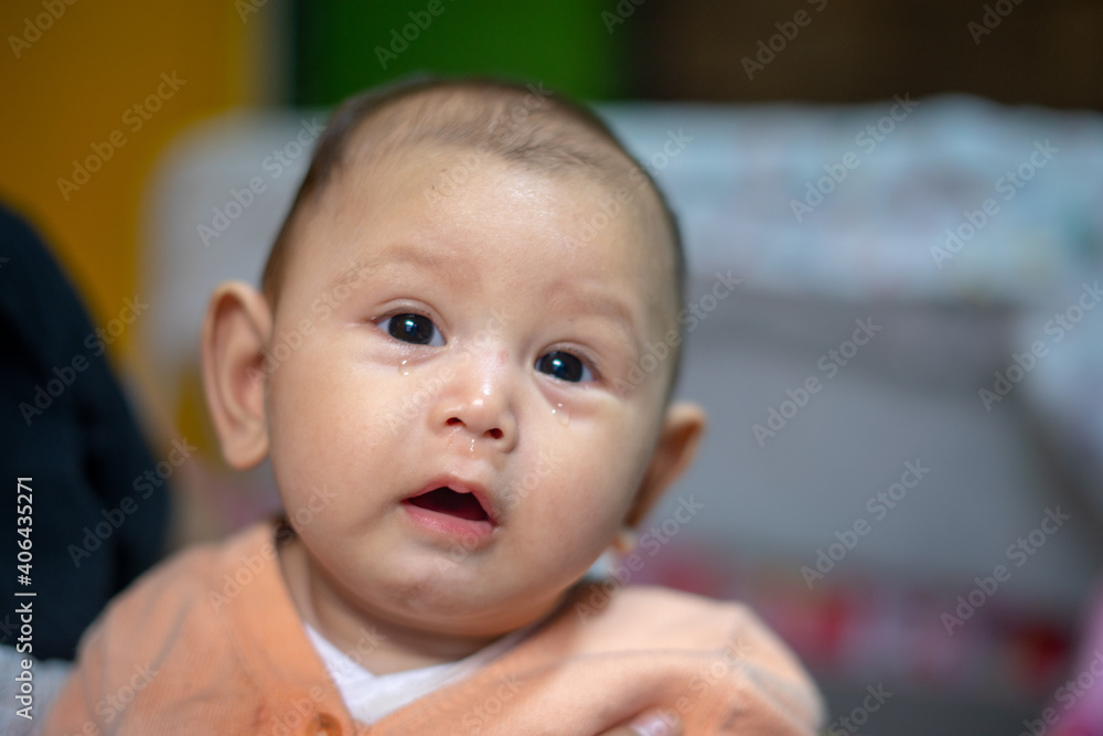 3 Month old baby girl with tears falling down her face 3 Month old baby girl with tears falling down her face