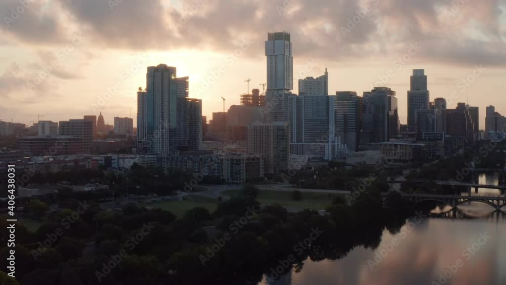 Sweeping Aerial during a summer sunrise over downtown Austin, TX, as the camera sweeps over lady bird lake, with reflections glowing off of the water, reverse movement. Sweeping Aerial during a summer sunrise over downtown Austin, TX, as the camera sweeps over lady bird lake, with reflections glowing off of the water, reverse movement.