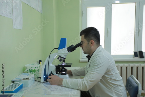 scientist looking through microscope