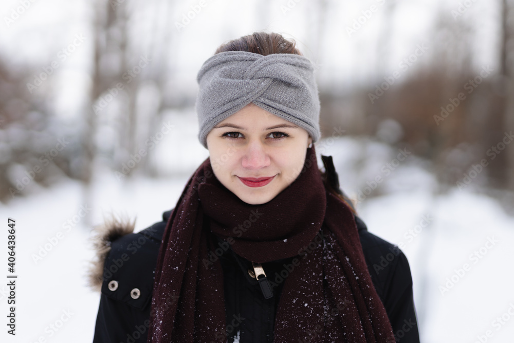 Young girl in winter clothes with snow background Young girl in winter clothes with snow background