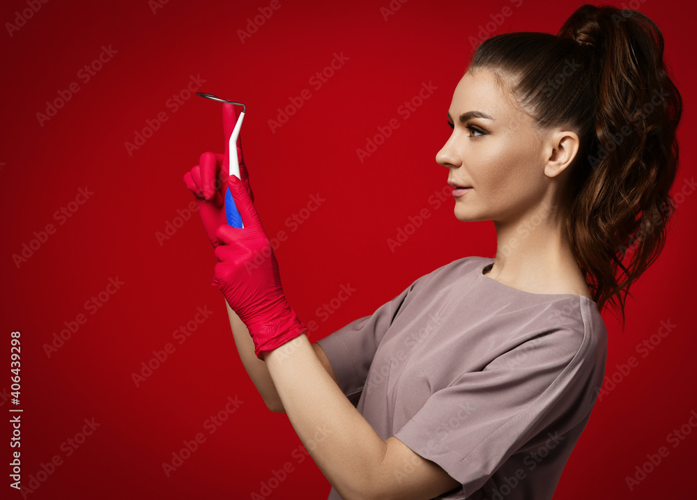 Gynecologist woman doctor physician reproductologist in latex gloves and uniform hold Transobturator sling to facilitate easy needle engagement and removal on red background. Gynecology concept Gynecologist woman doctor physician reproductologist in latex gloves and uniform hold Transobturator sling to facilitate easy needle engagement and removal on red background. Gynecology concept