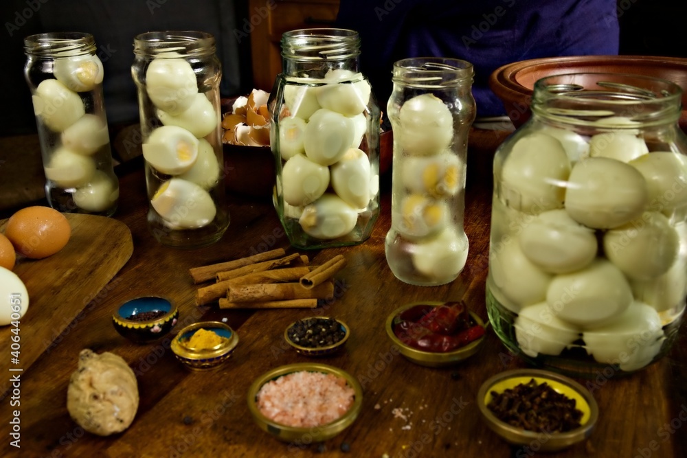 Ταπετσαρία Jars filled with boiled eggs for pickling with pickling spices sitting in the fo