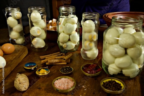 Foto Jars filled with boiled eggs for pickling with pickling spices sitting in the fo