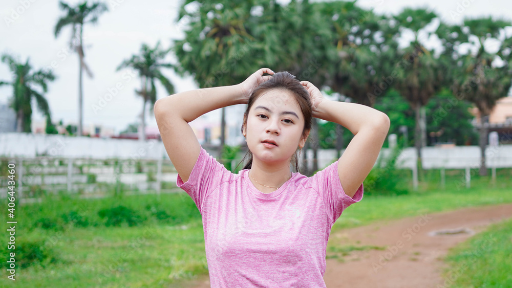 asian runner woman tying hair in stadion