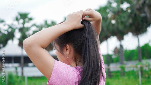 asian runner woman tying hair in stadion
