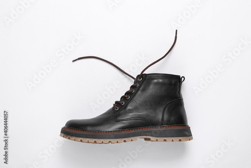 Stylish men's leather boot with untied laces on a white background