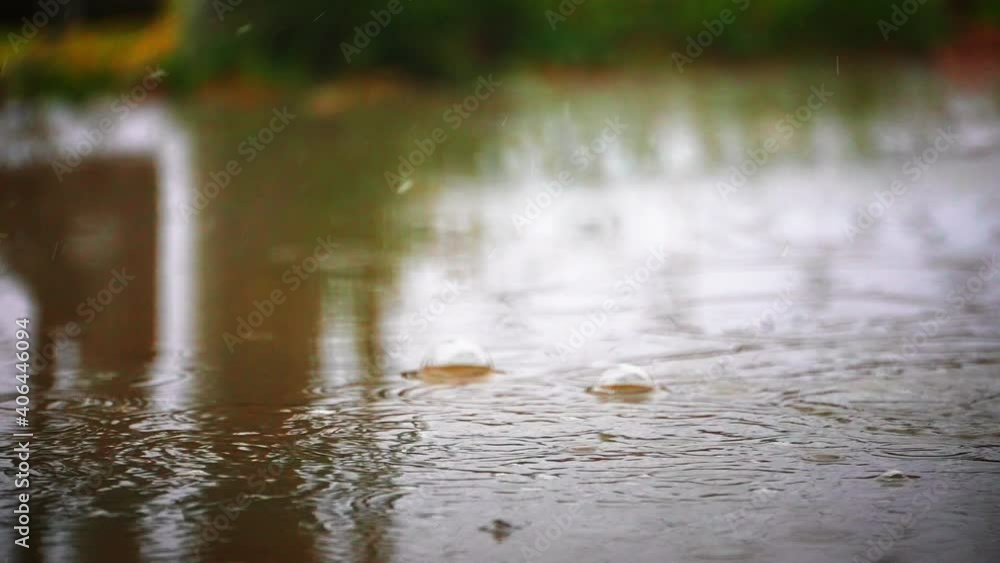 Rain droplets falling a splashing in a puddle with some forming bubbles - slow motion Rain droplets falling a splashing in a puddle with some forming bubbles - slow motion