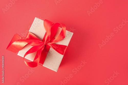 Valentines day greeting card with gift box on red background. Copy space for greetings.