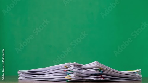 4K-Stop motion Stack overload document report paper with colorful paperclip on green background, business concept footage paperless used.