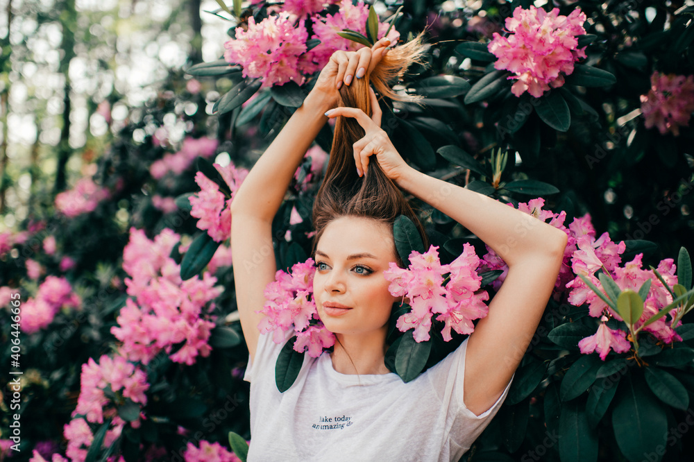 Obraz premium Young beautiful girl posing among the flowering tree