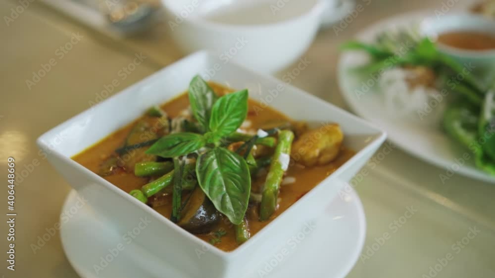 Bowl Of Kare-Kare Stew Dish With Vegetables And Peanut Sauce Top With Basil Leaves. - close up
Bowl Of Kare-Kare Stew Dish With Vegetables And Peanut Sauce Top With Basil Leaves. - close up