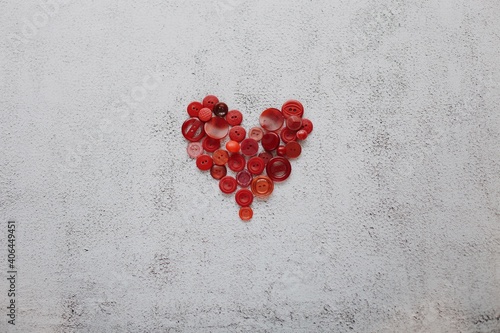 Different bottons in heart shape on natural background. Valentine's Day concept greeting card photo