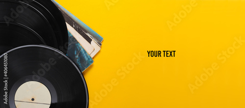 Vinyl record albums isolated on yellow background. Copy space. Top view photo