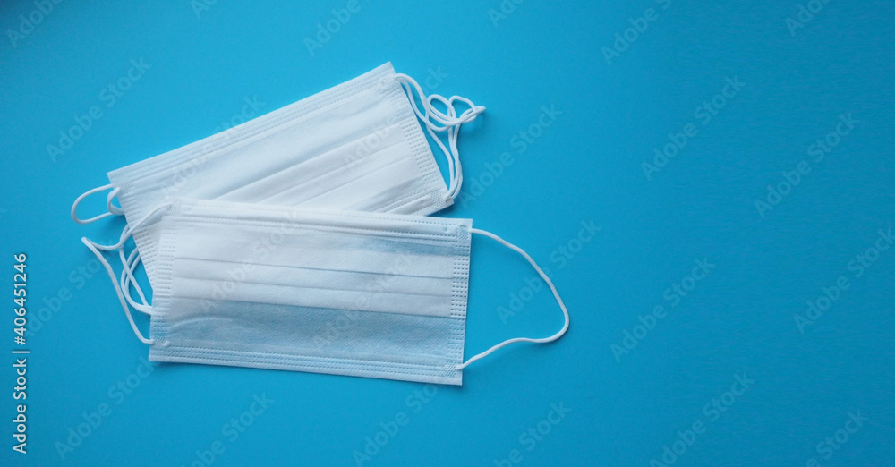 Group of white face masks isolated on blue background.no people and health care concept Group of white face masks isolated on blue background.no people and health care concept