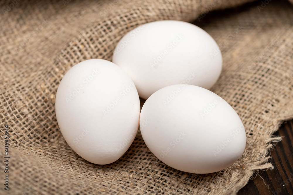 Chicken eggs on a background of homespun fabric with a rough texture. Close-up, selective focus. Chicken eggs on a background of homespun fabric with a rough texture. Close-up, selective focus.