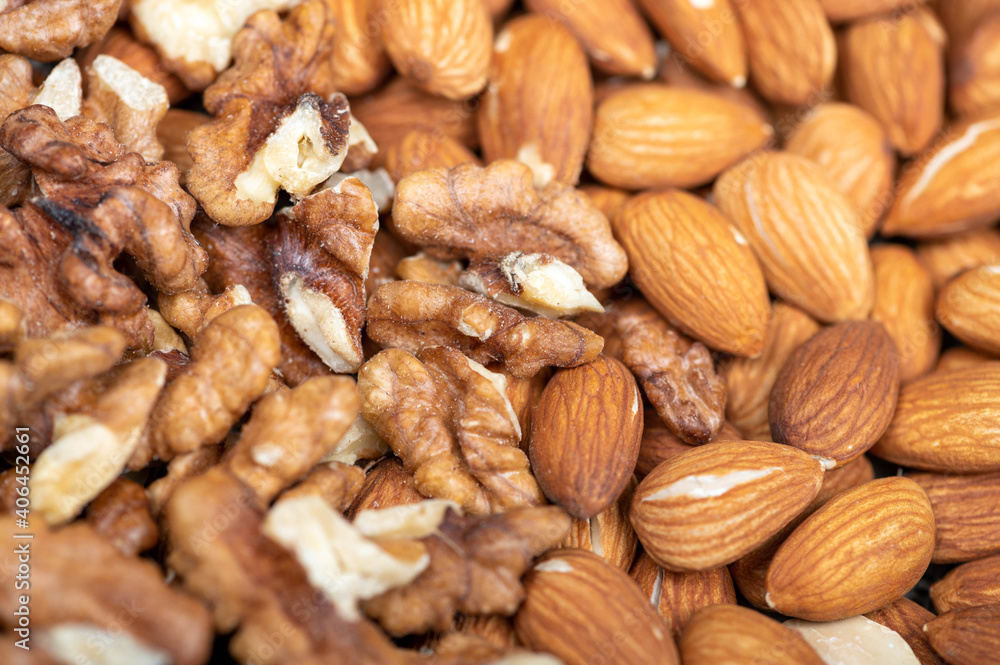 Almonds and walnuts scattered on the table. Close-up, selective focus. Almonds and walnuts scattered on the table. Close-up, selective focus.