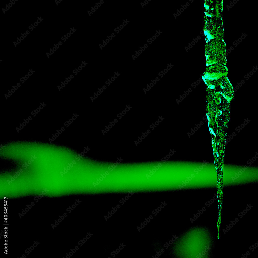 dynamic image showing an icicle with a green glow. suquare croped - obrazy, fototapety, plakaty 