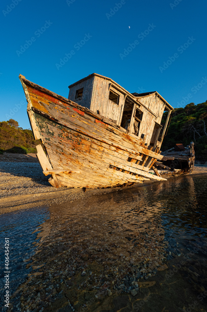 Shipwreck abandoned at a beach of Skyros island in Greece in sunset