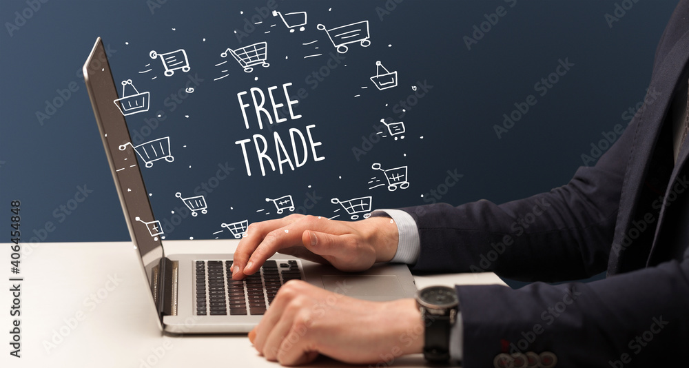 Businessman working on laptop with FREE TRADE inscription, online shopping concept Businessman working on laptop with FREE TRADE inscription, online shopping concept