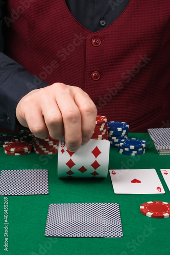 Photography the dealer's hand shows the hole card to the player in the poker game, close-up