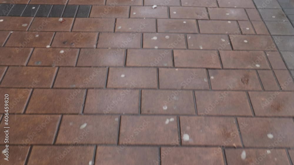 First person view walking on the wet pedestrian sidewalk slippery from melted snow with camera shake First person view walking on the wet pedestrian sidewalk slippery from melted snow with camera shake