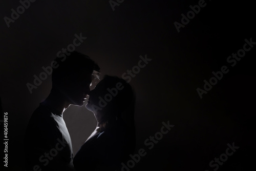 Side view of happy young couple celebrating Valentine's Day together. Beautiful couple is kissing. Beautiful young couple smiling while sitting face to face