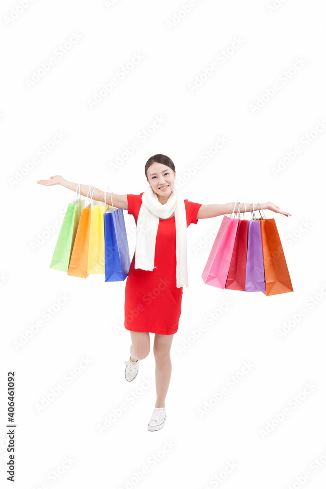 Portrait of young woman holding up shopping bags,opening arms Portrait of young woman holding up shopping bags,opening arms