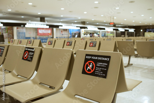 Empty bench seats with social distancing sticker signs during COVID-19 pandemic in Japan　新型コロナウイルス対策で使用禁止のステッカーが貼られたベンチ ソーシャルディスタンス 成田空港 photo