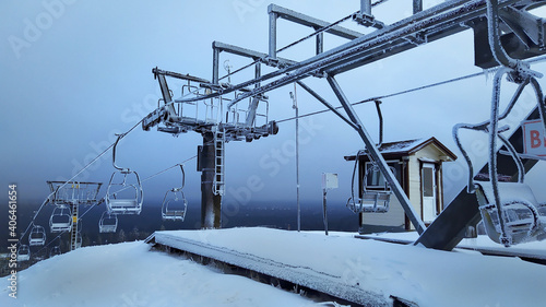 A frozen and abandoned Chairlift in the snowy mountains. A devastated ska lift covered with snow and frost.