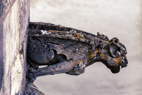 Element of decor of the cathedral with gargoyles. Gothic architecture. Stone statue on the wall of the Catholic Cathedral in the form of the demon with wings.