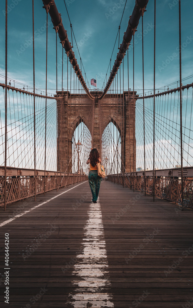 Obraz premium Vertical view from below of Brooklyn Bridge - a hybrid cable-stayed suspension bridge in New York City, spanning the East River between the boroughs of Manhattan and Brooklyn. 