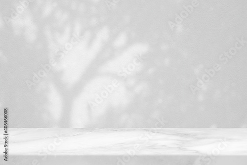 White Marble Table with Tree Shadow in the Park on Concrete Wall Texture Background, Suitable for Product Presentation Backdrop, Display, and Mock up.