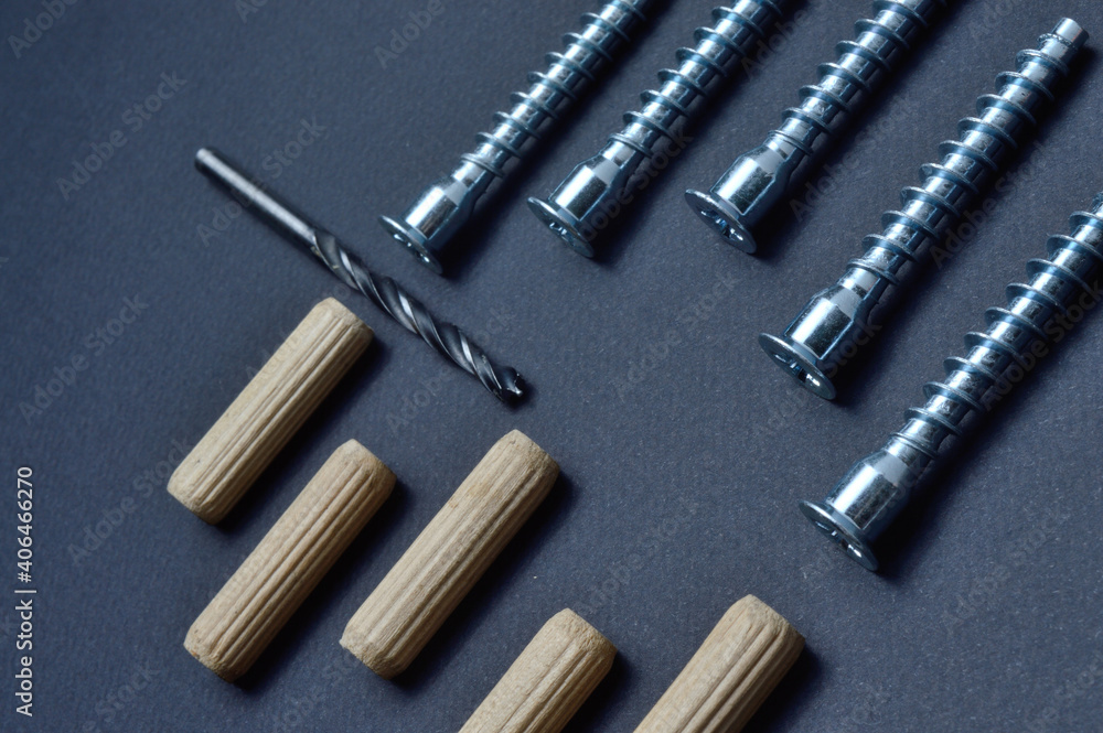 furniture assembly fittings and drill. lie on a dark background. close-up. furniture assembly fittings and drill. lie on a dark background. close-up.