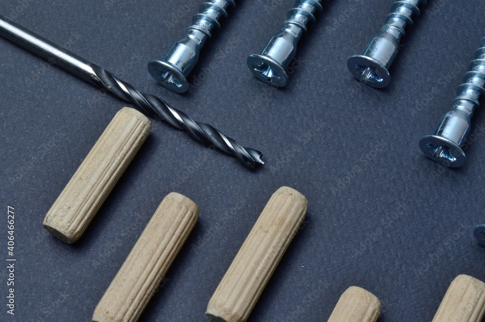 furniture assembly fittings and drill. lie on a dark background. close-up. furniture assembly fittings and drill. lie on a dark background. close-up.