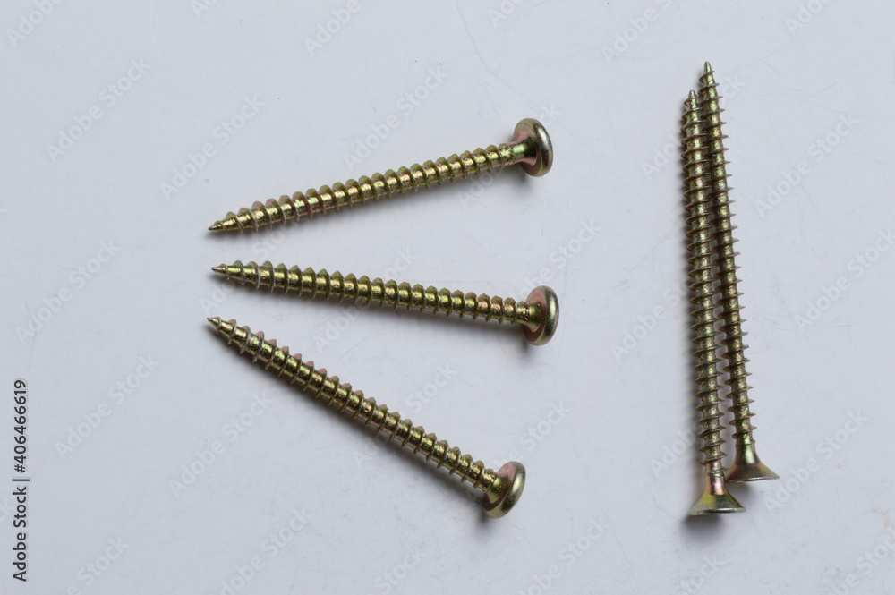 several yellow screws lie on a light background. close-up. several yellow screws lie on a light background. close-up.