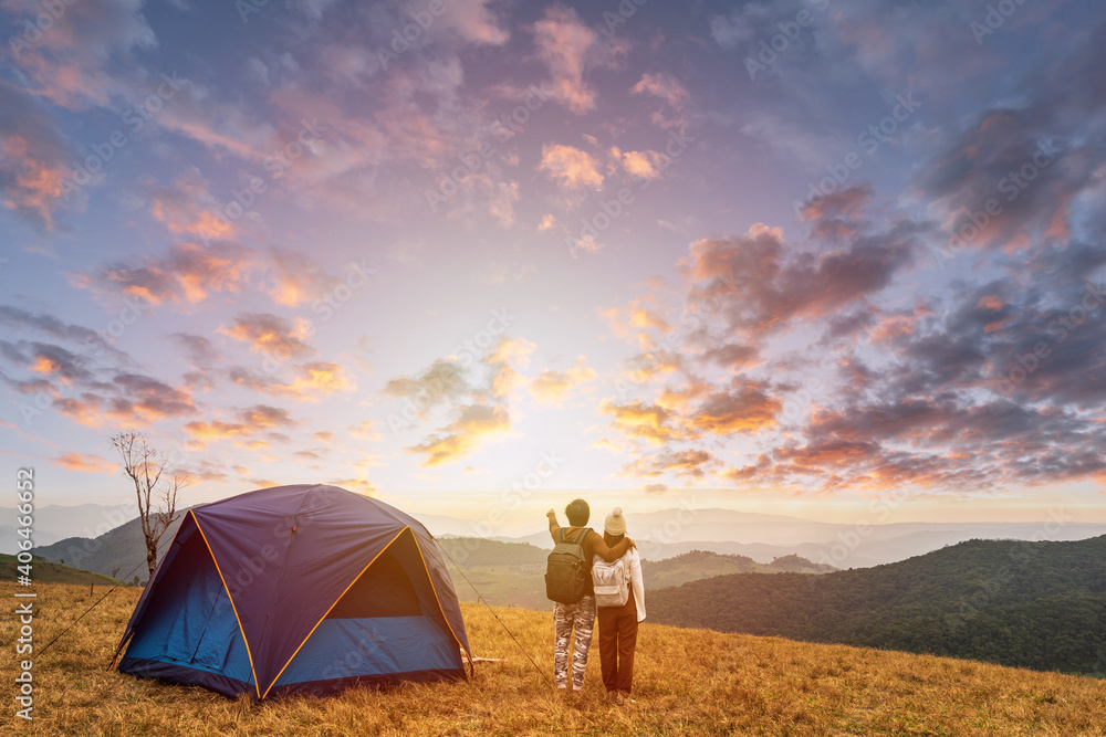Young couple traveler looking landscape at sunset and camping on mountain, Adventure travel lifestyle concept