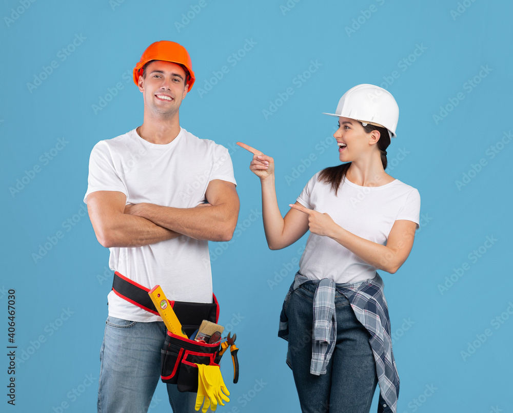 Cheerful Couple In Hard Hats And Casual Clothes Having Fun During Repair Cheerful Couple In Hard Hats And Casual Clothes Having Fun During Repair
