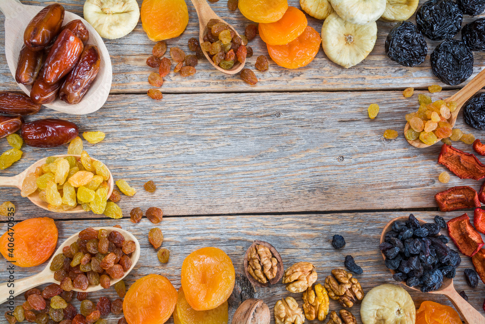 Fototapeta premium Frame of different dried fruits on a wooden background