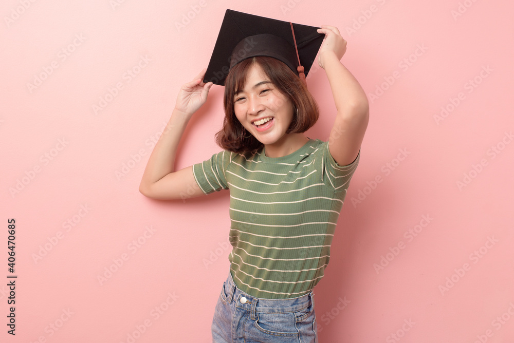 Portrait of young Asian student wearing graduation cap over studio background. Portrait of young Asian student wearing graduation cap over studio background.
